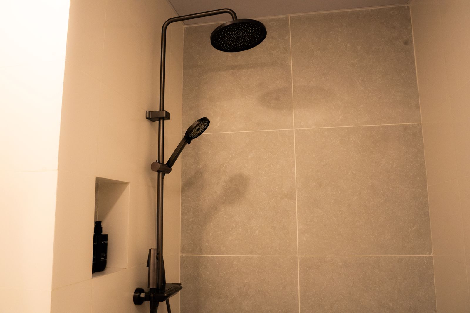Matte black rain shower with recessed toiletry niche