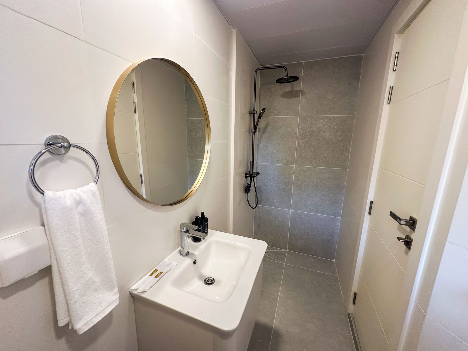 En-suite with vanity, round mirror and walk-in rain shower