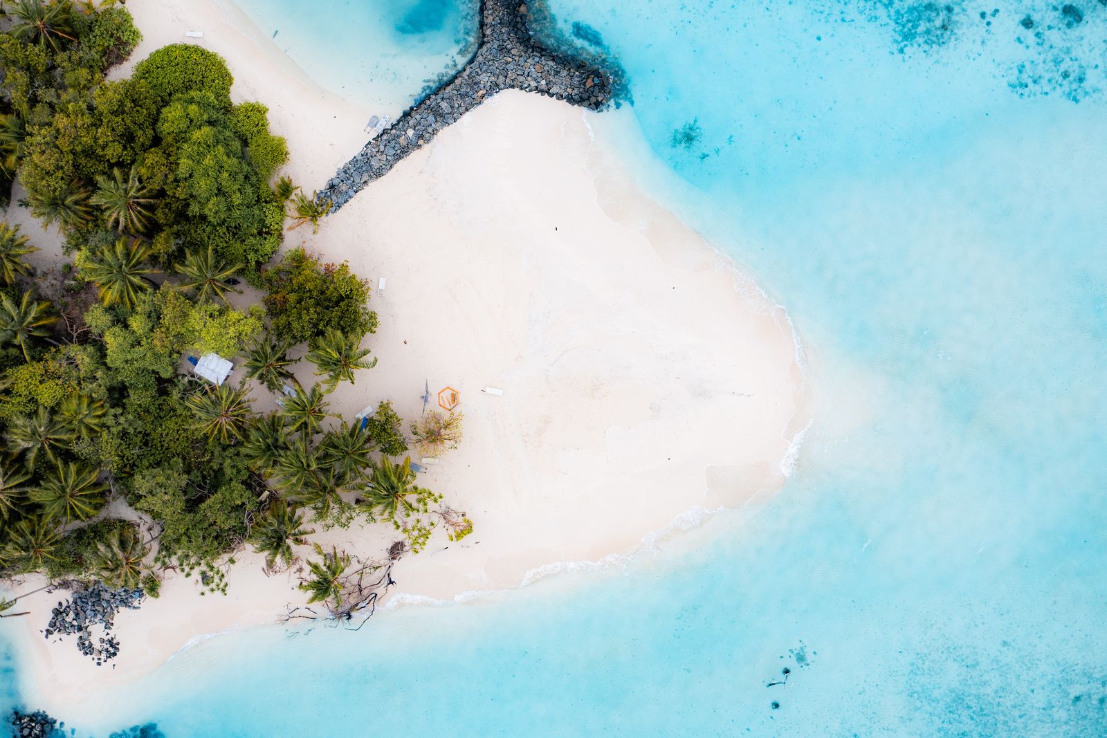 Wide overhead view of the beach, groyne and empty white sand