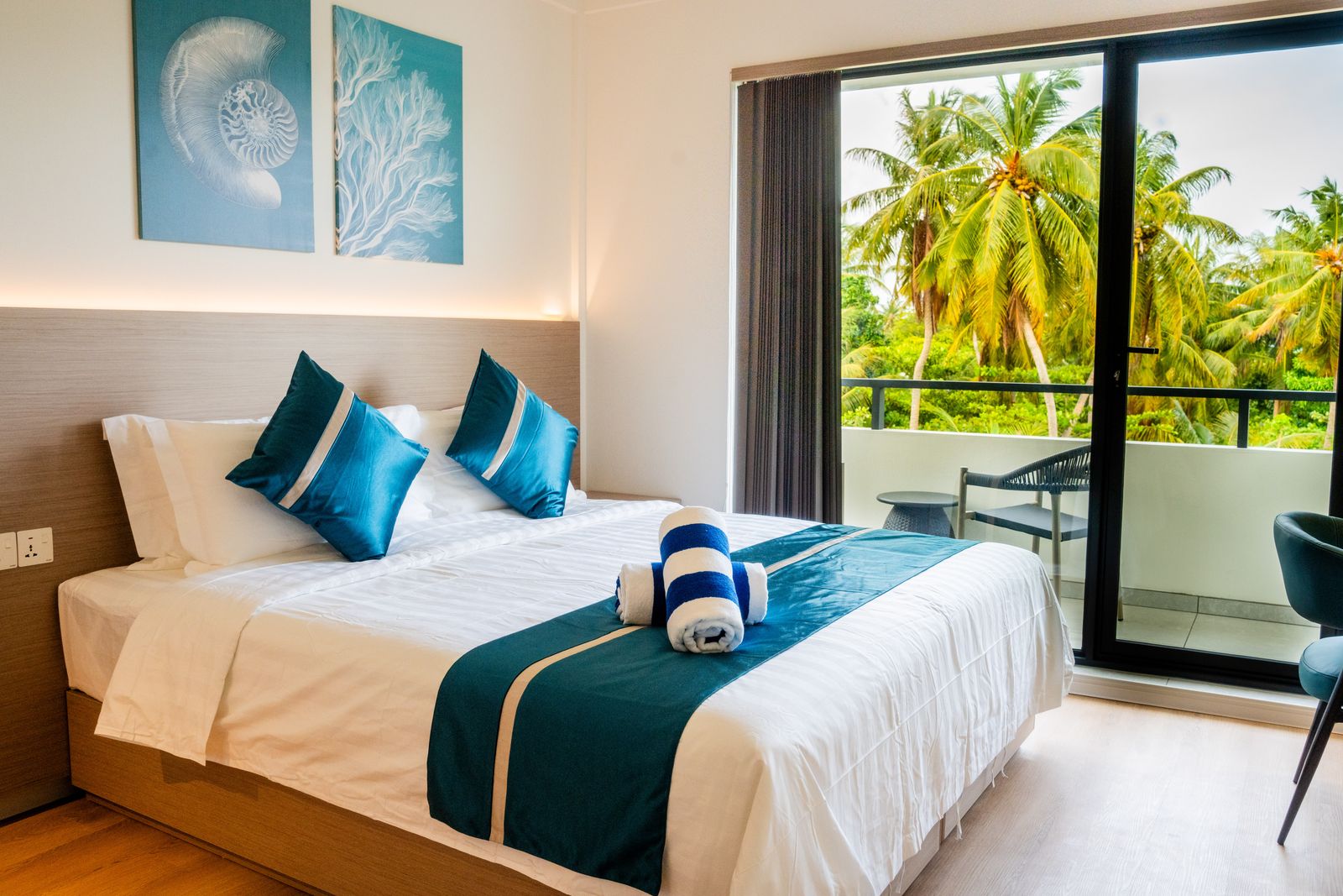 Deluxe room with coral artwork and balcony doors