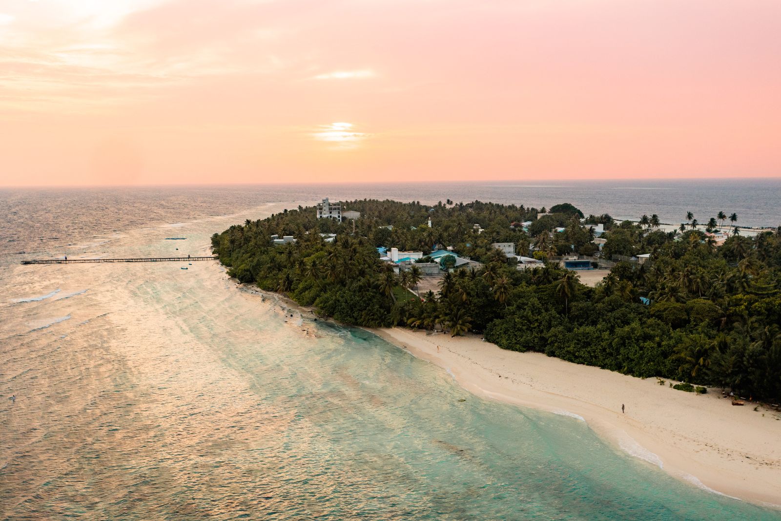 Omadhoo at sunset, the sky turning pink over the reef