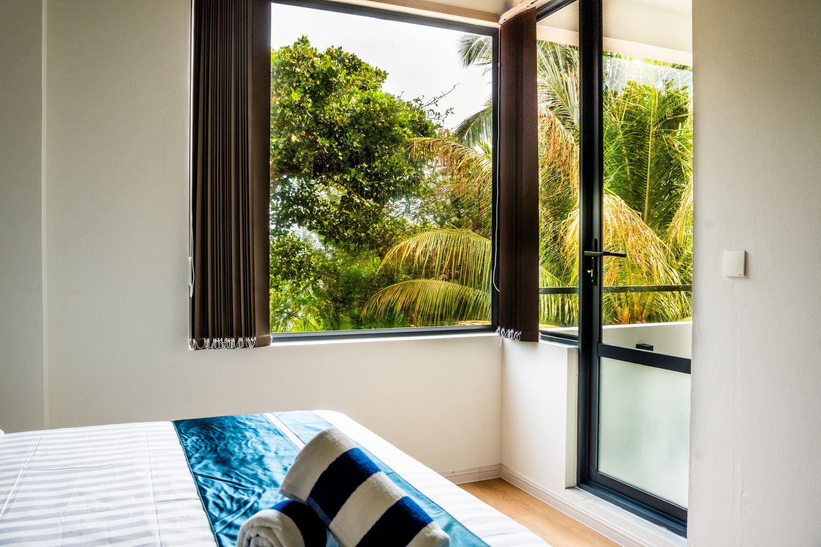 Corner window looking out to palms and island greenery