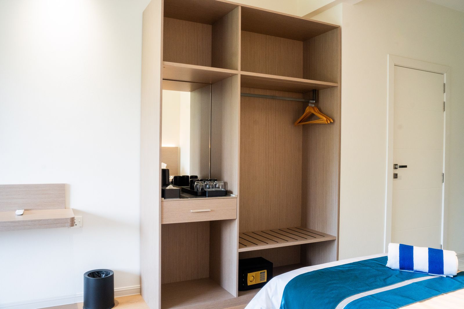 Open wardrobe with hangers, in-room safe and tea station