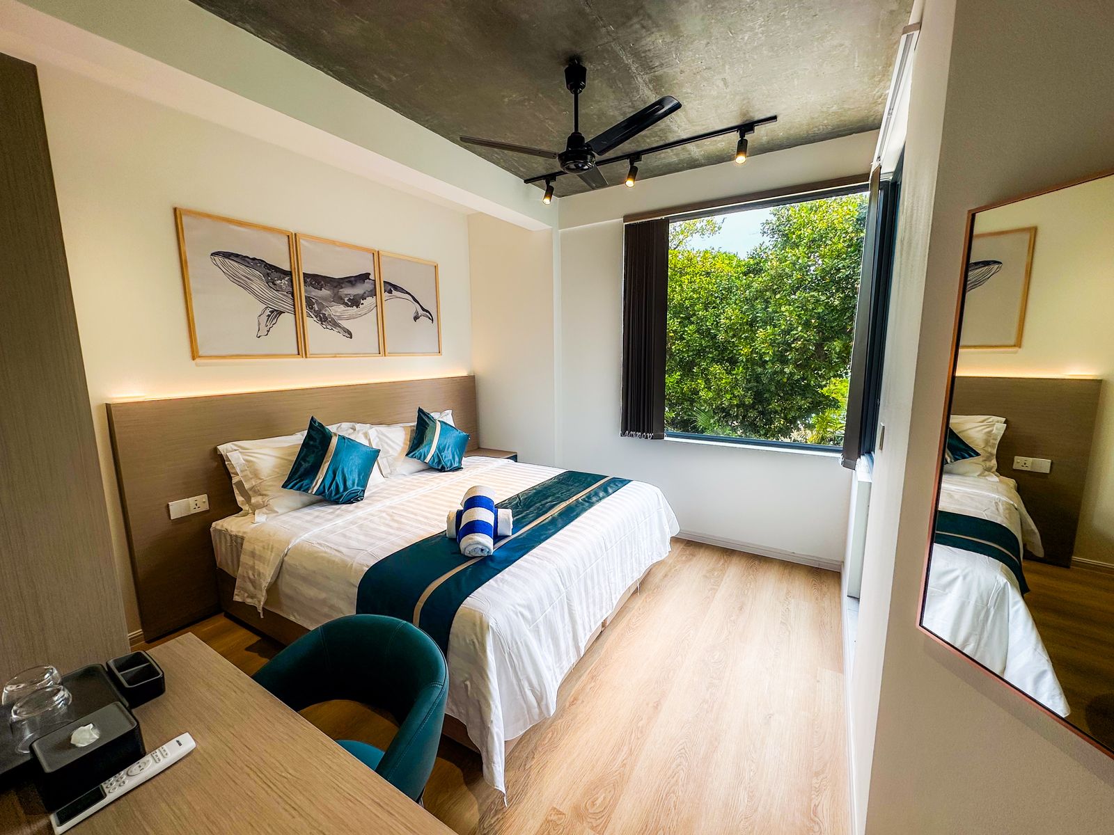 Guest room with whale triptych, ceiling fan and garden view